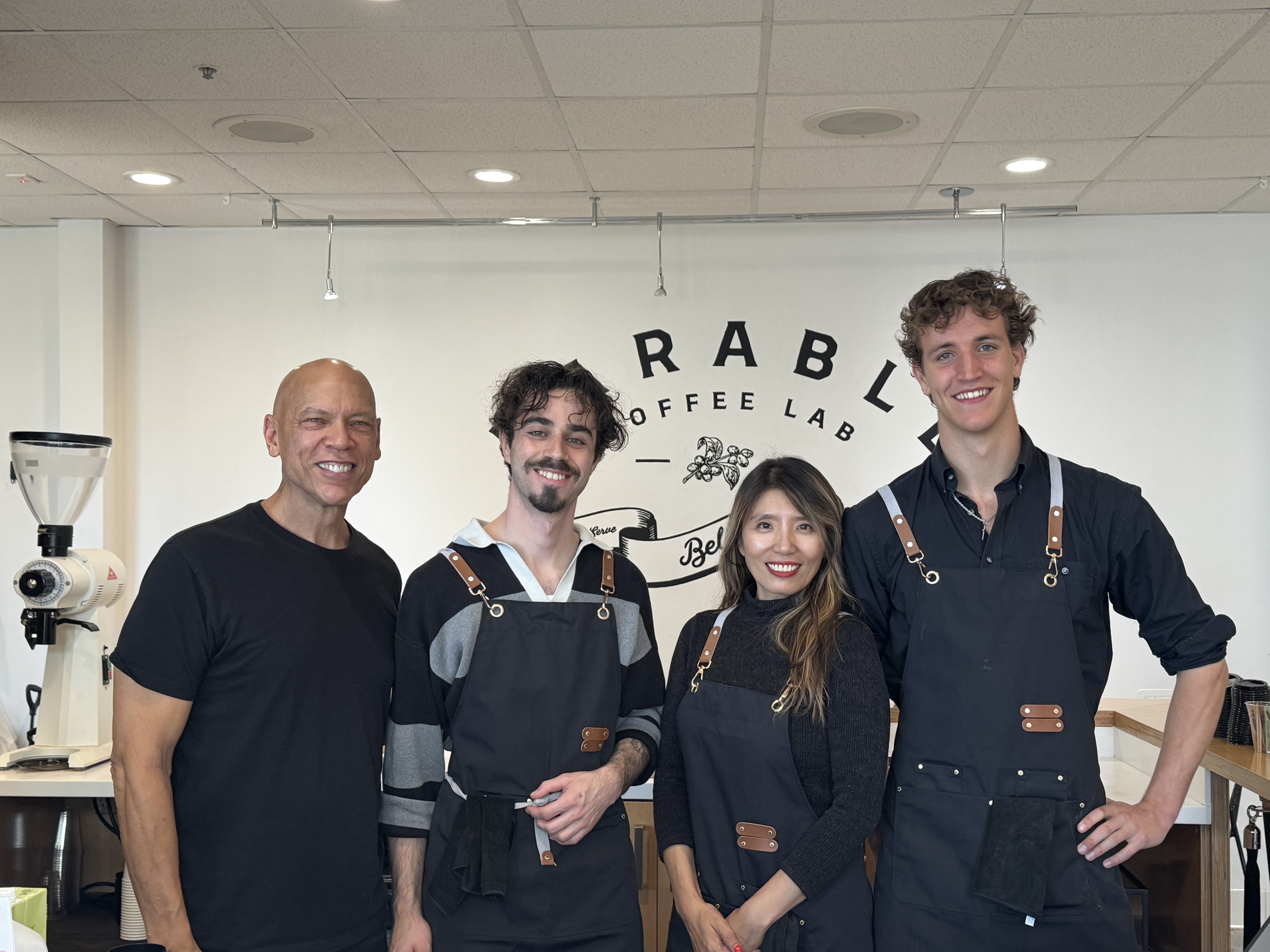 Rafael standing with coworkers inside Rabble Coffee Lab
